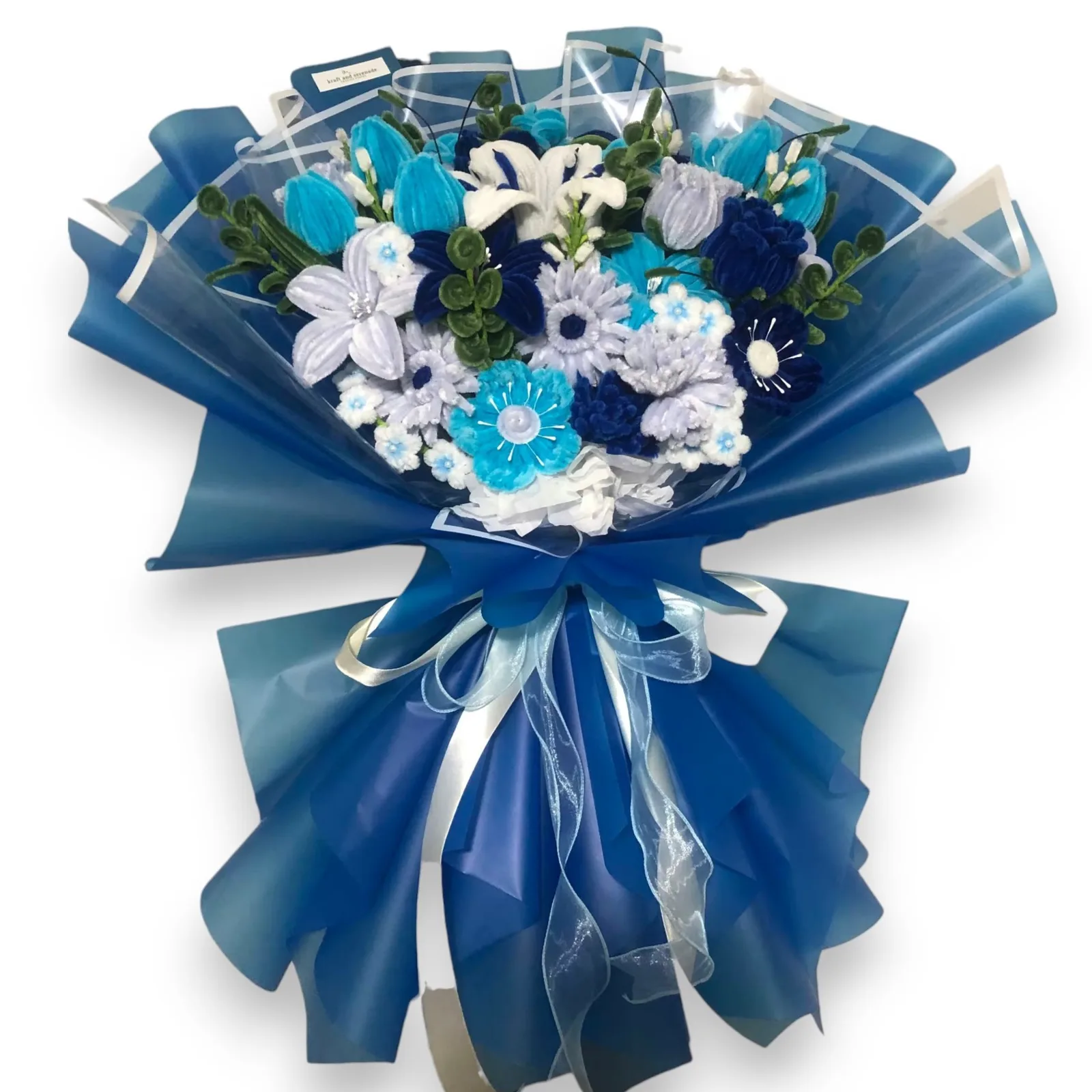 The arrangement features tulips, lilies, gerberas, carnations, roses, and poppy flowers, complemented by mini daisies, baby's breaths, and leaf strands as fillers.