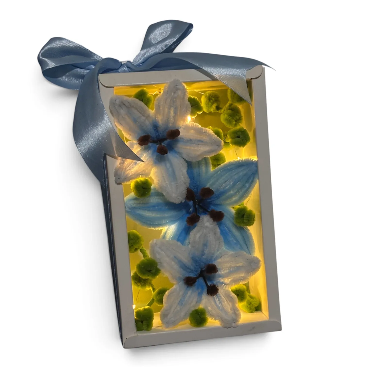 The arrangement features lilies, complemented by small flower buds as fillers.